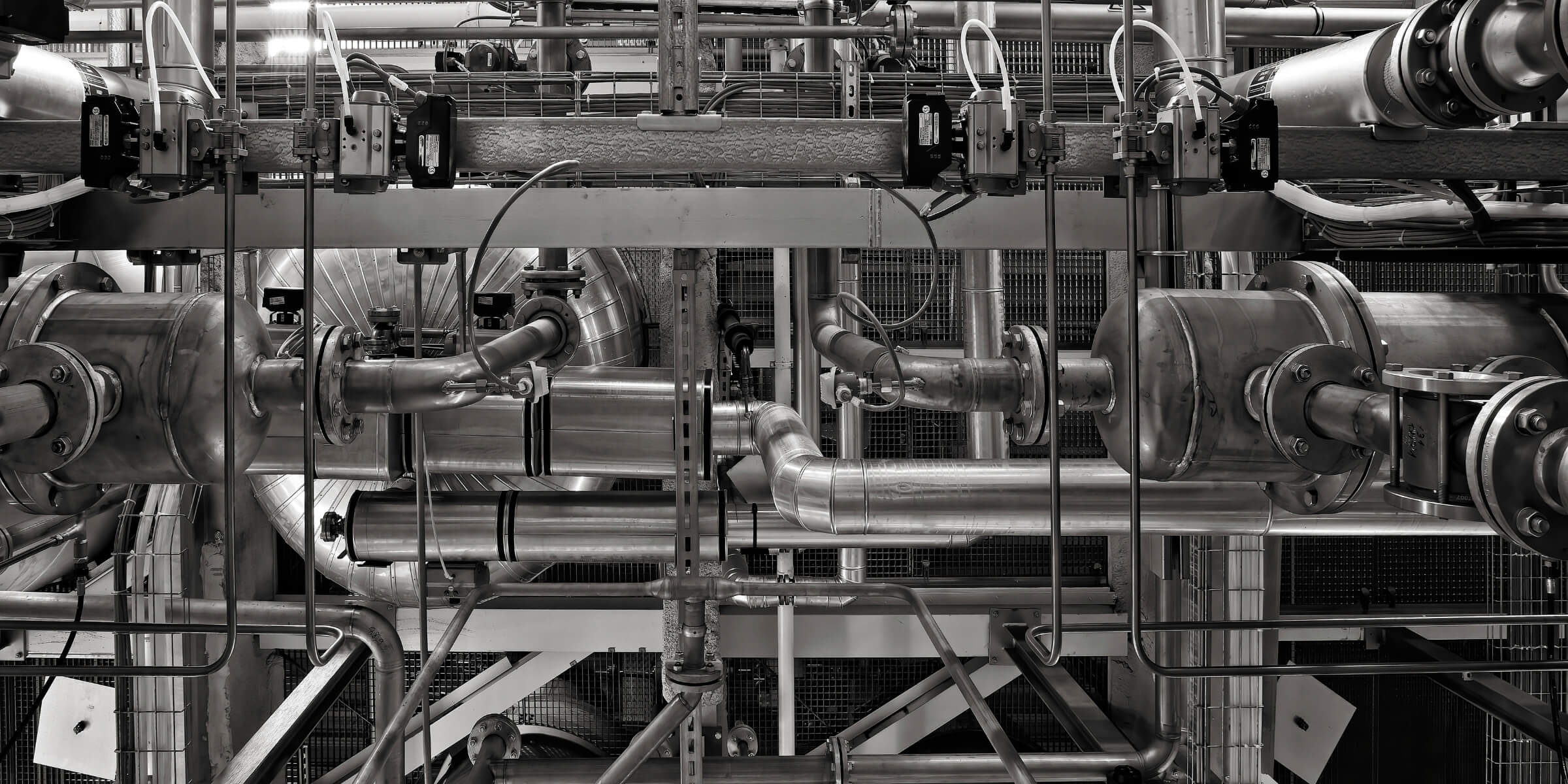 Interior de planta industrial con tuberías y equipos de proceso. GM Nexus Industrial, mantenimiento industrial